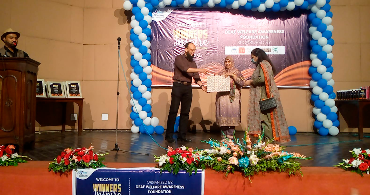 Tanzeela Aziz receiving her certificate on stage