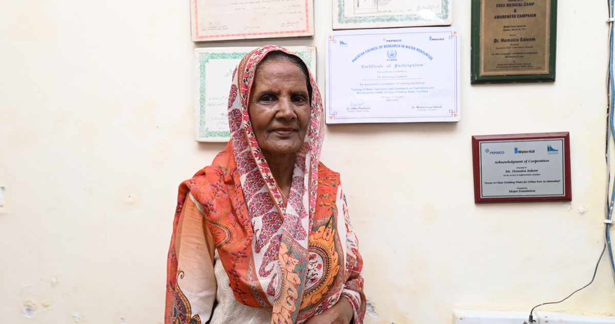 Dr. Humera Saleem stands in front of her certificates in her clinic
