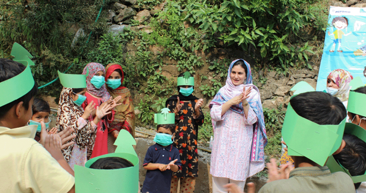 Women and children practice washing their hands